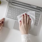 Cleaning laptop with antibacterial wipe