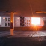 Empty parking garage with skyscrapers and sunset visible in background