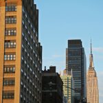 New York City skyline with Empire State Building and neon "PARK" sign in foreground