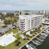 Marina Place condo seen from above, with swimming pool, palm trees, and harbor full of boats in the foreground